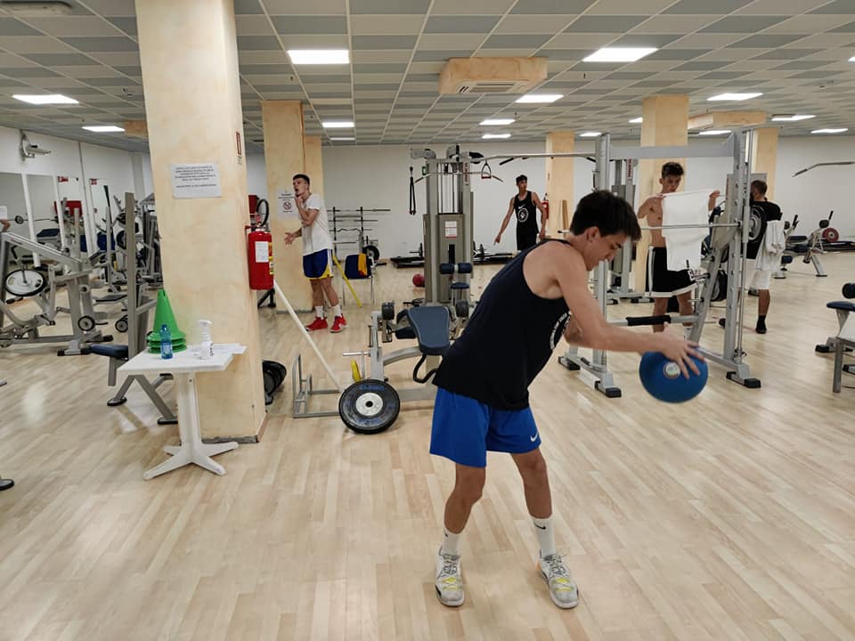 Jugendliche beim Training mit Medizinball und Kraftgeräten im Fitnessraum