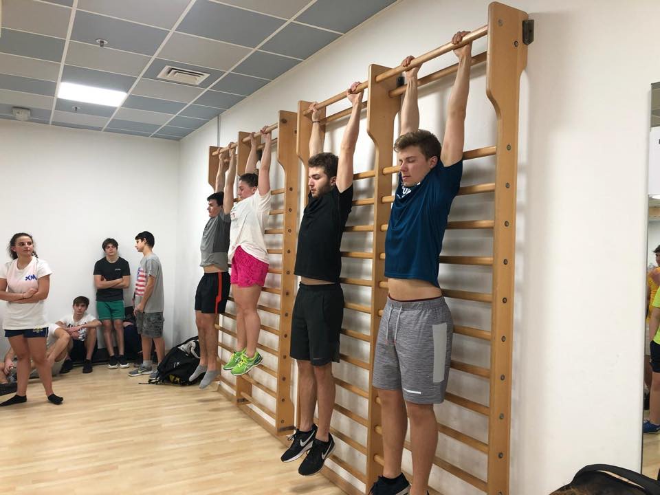 Schüler hängen an der Sprossenwand im Fitnessraum, daneben wartet die Gruppe