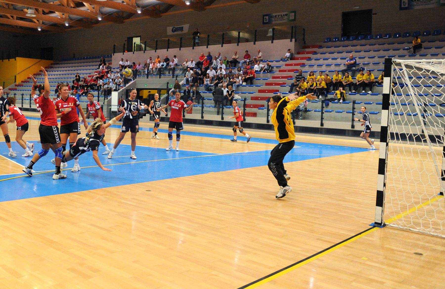 Handballspiel in der Sporthalle vor besetzter Tribüne