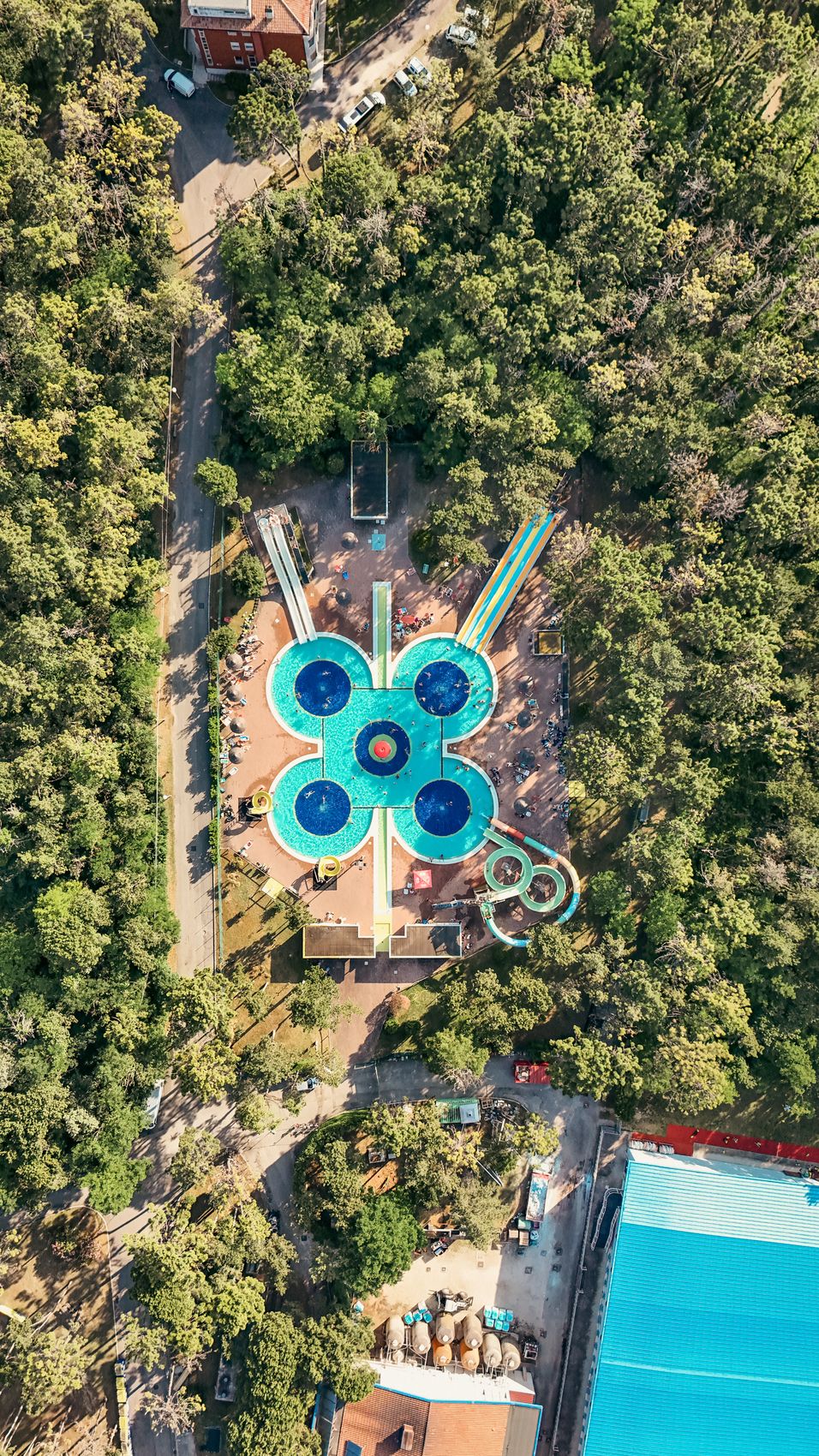 Der Wasserpark Aquagiò von oben: 4 runde Becken um einen Themenpool, Rutschen und Pinienwald ringsum