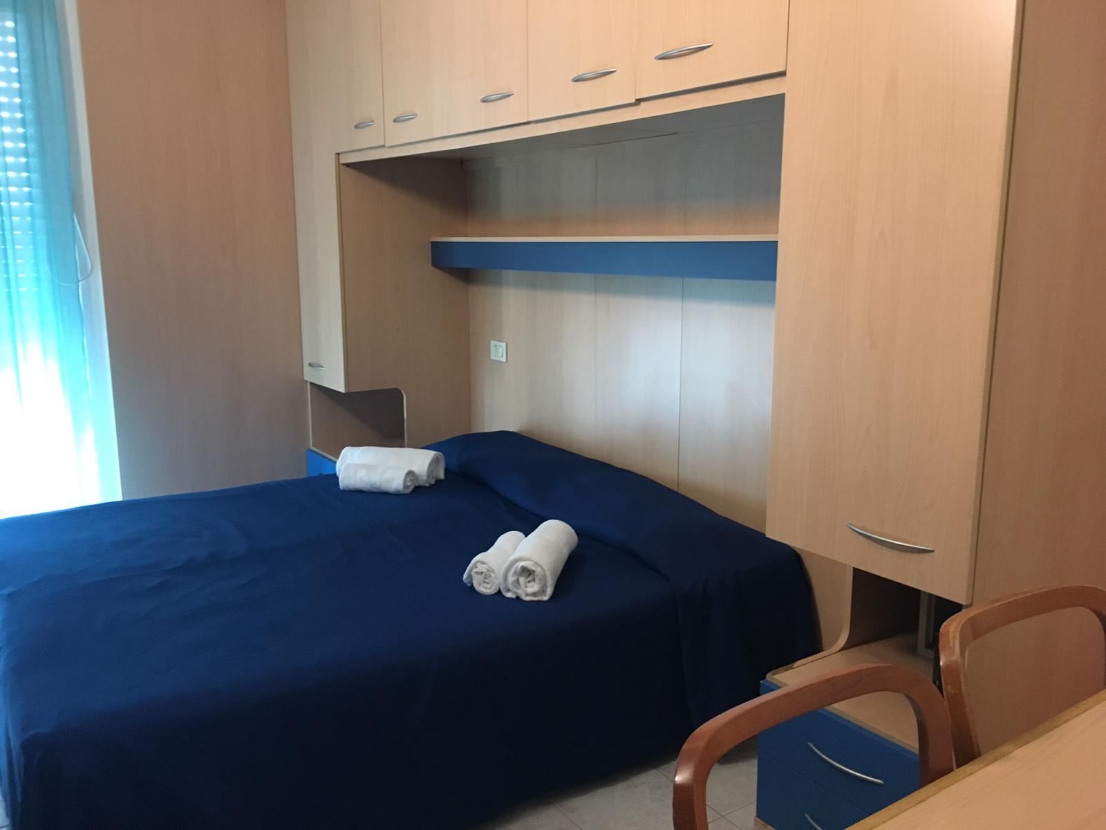 Doppelzimmer mit Einbauschrank und Handtüchern auf dem Bett