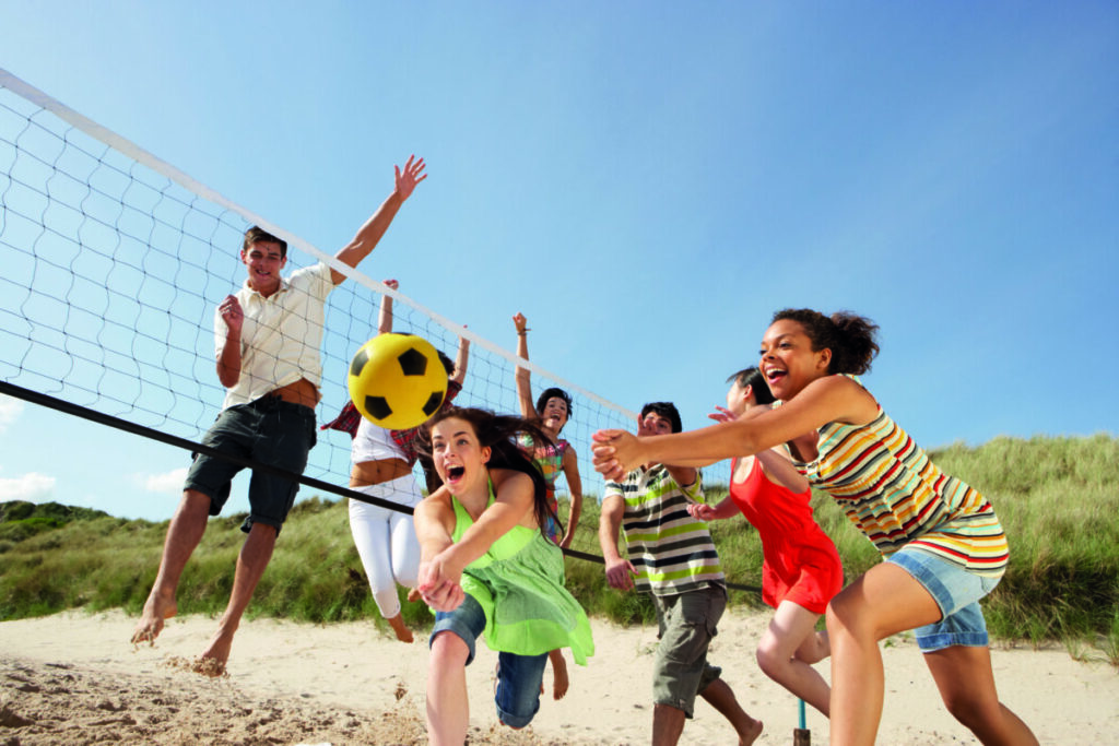 Teenage Friends Playing Volleyball On Beach